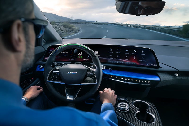 Front View of the 2026 OPTIQ-V Driving Through the Dusk Utilizing its Headlights | Johnson Cadillac in BUDD LAKE NJ